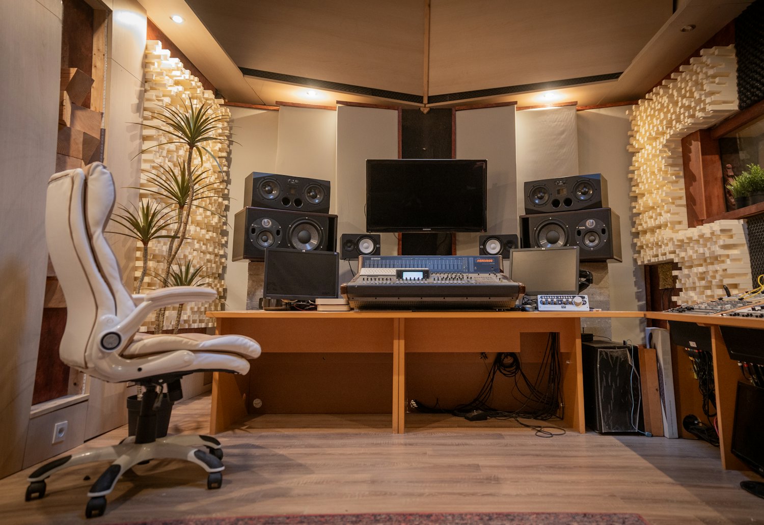 A production studio with monitors, speakers and acoustic wall treatment.